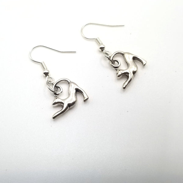 silver yoga cat earrings on white background