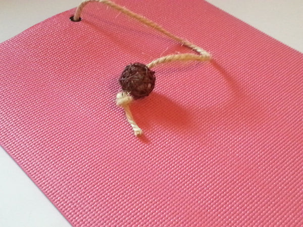 pink yoga cat mat with attached rattan catnip ball